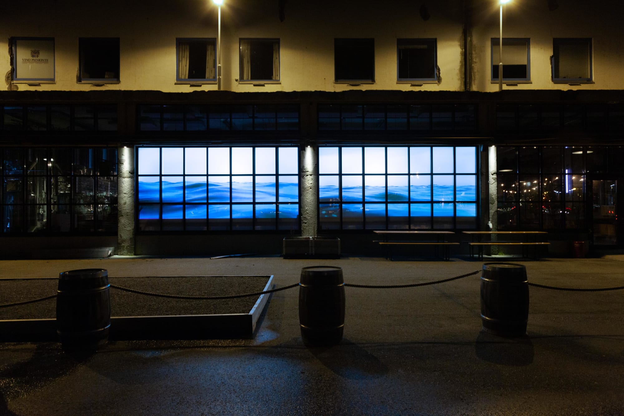 Tight shot of Water Will Be Here projected into the windows of Molo Brew